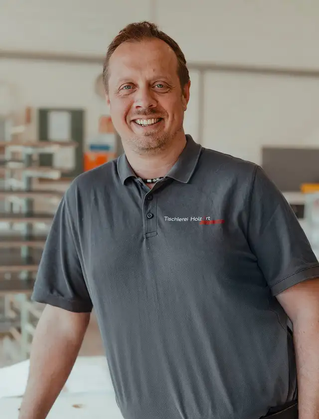 Mitarbeiter Dirk lacht in die Kamera.