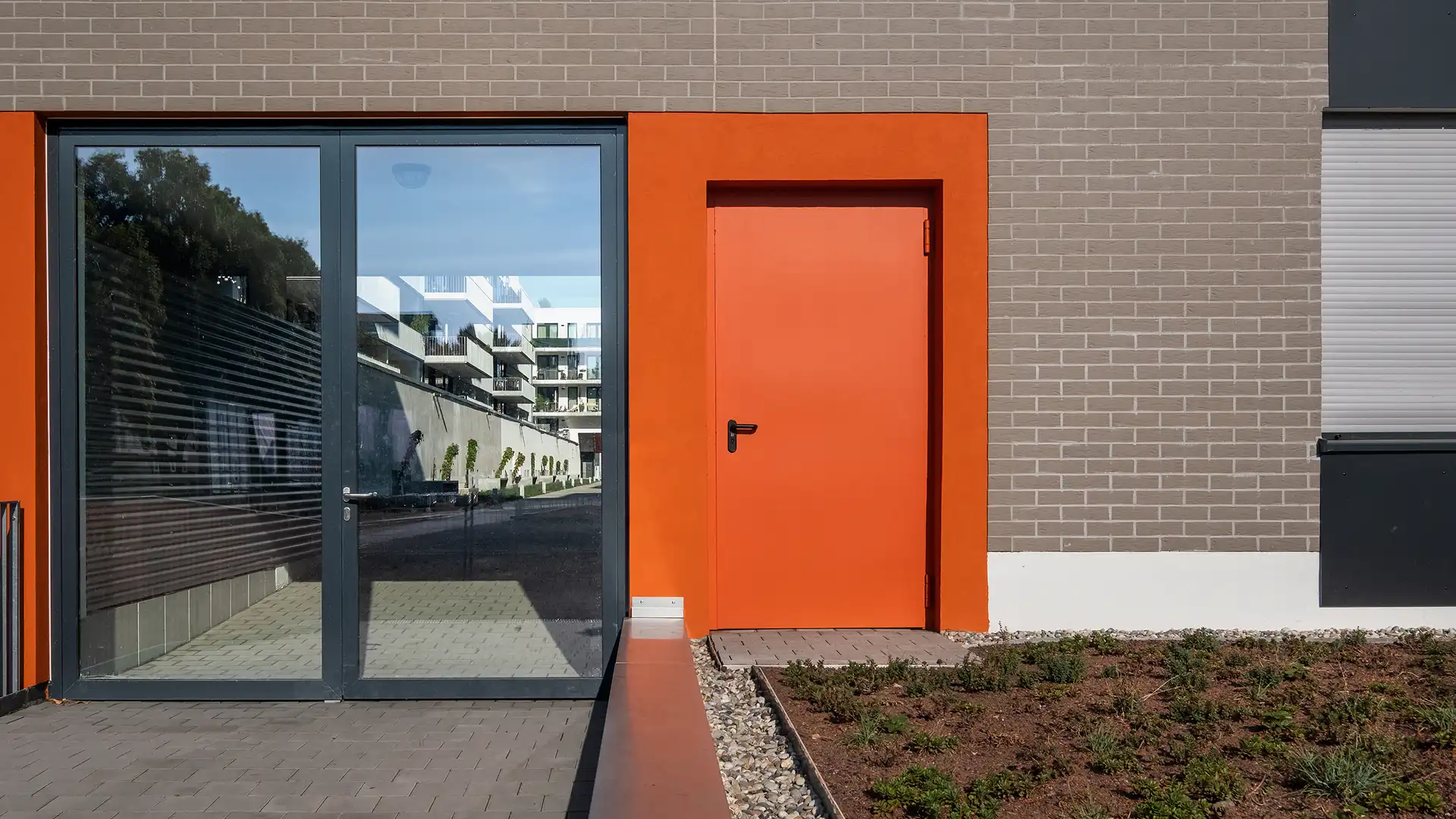 Knallig Orange Brandschutztür außen an einem Gebäude.