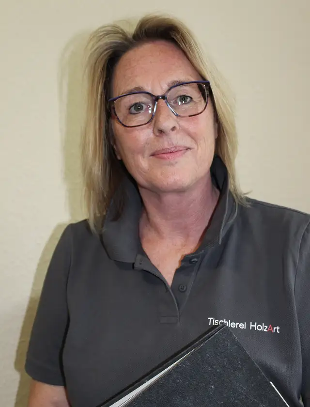 Portrait von Nicole die in die Kamera lacht.
