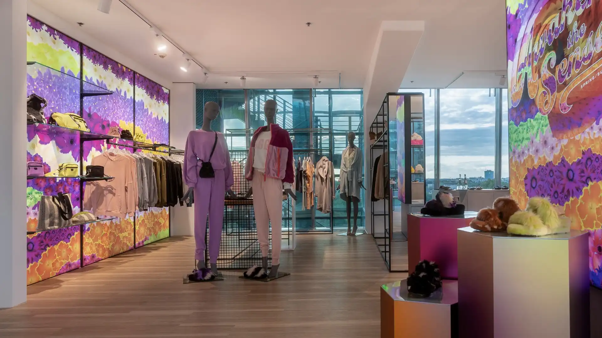 Farbenfroher Mode-Showroom mit beleuchteten Präsentationswänden, Regalen und Schaufensterfiguren